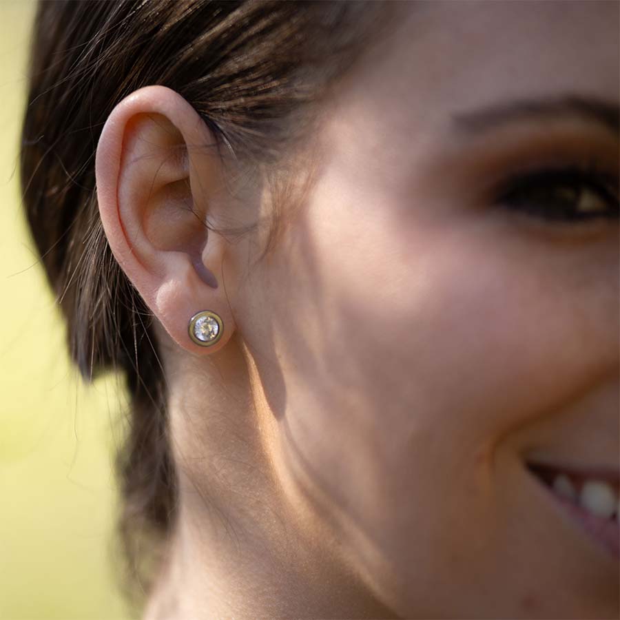 Close-up of a person wearing Crystal Bezel Titanium ComfyEarrings