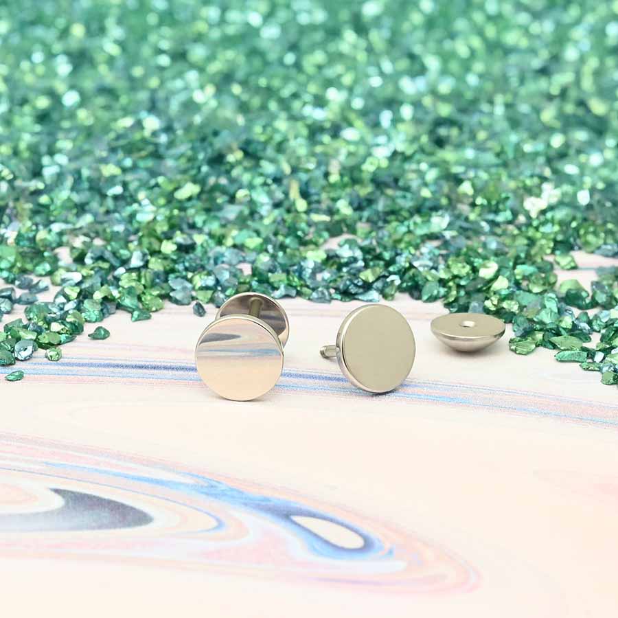 stainless stud earrings on a colorful, glittery background