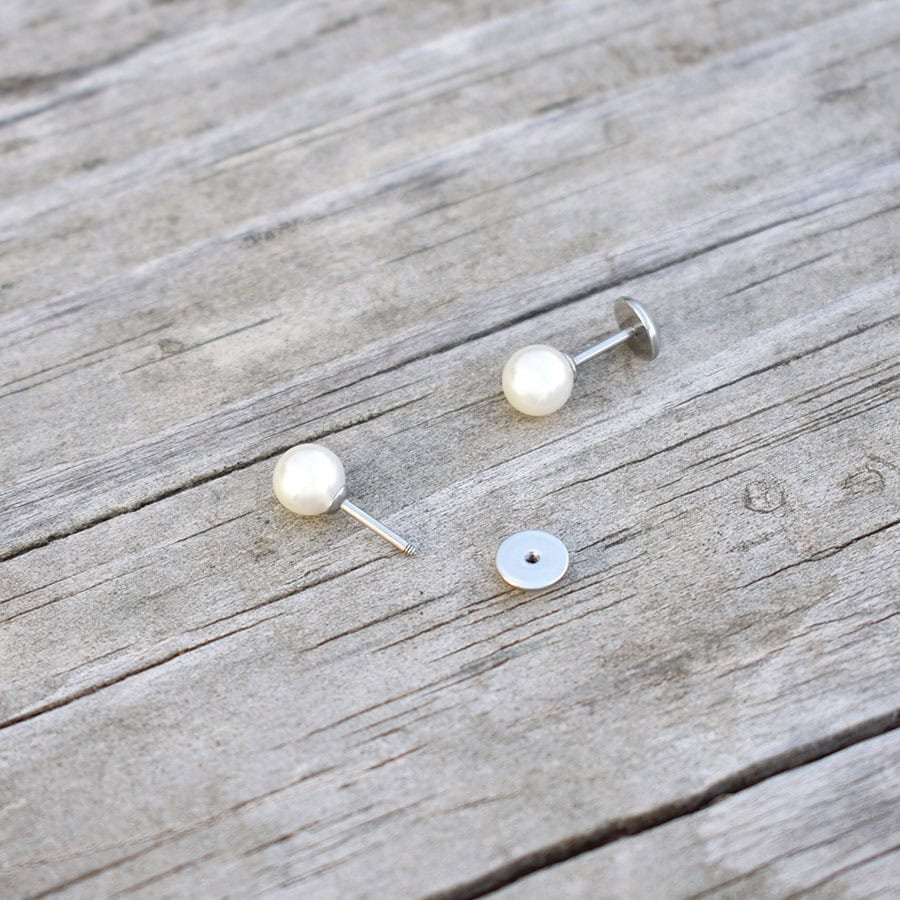 Classic Pearl ComfyEarrings sitting on weathered wood