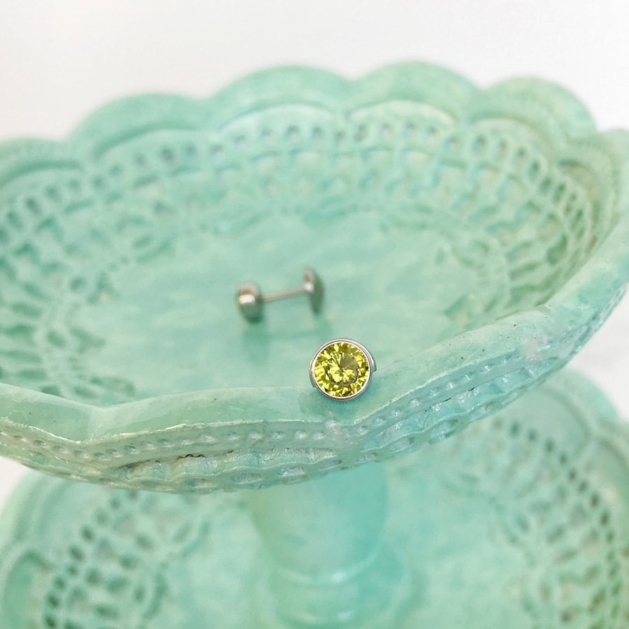 Peridot ComfyEarrings sitting on a blue green dish