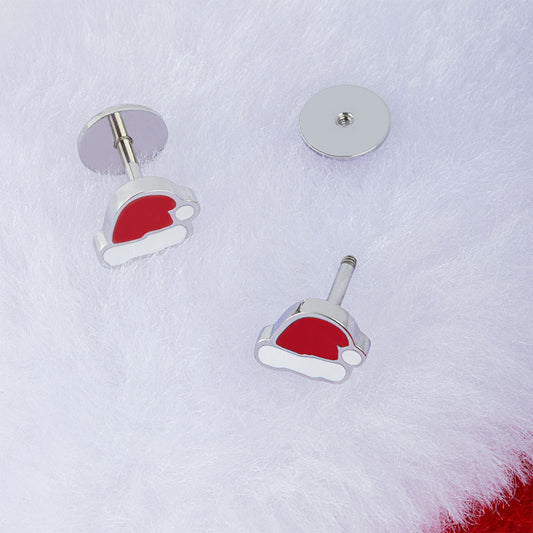 A pair of silver-tone stud earrings shaped like Santa hats with red and white enamel, displayed on a white faux fur background.