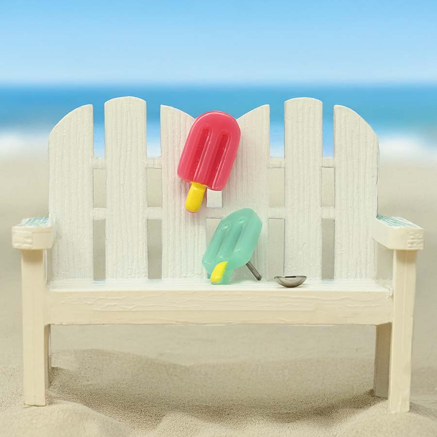 Beach scene with a wooden bench, popsicles, and a picket fence. Featuring homemade popsicle DIY ComfyEarrings.