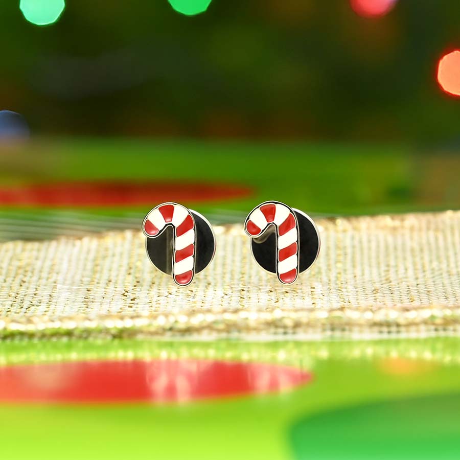 Candy cane-shaped earrings on a gold ribbon with a festive background