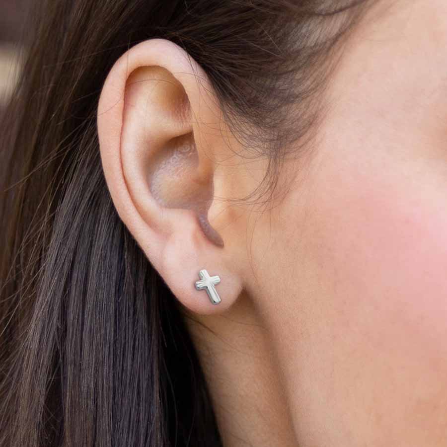 Close-up of a woman wearing a cross earring