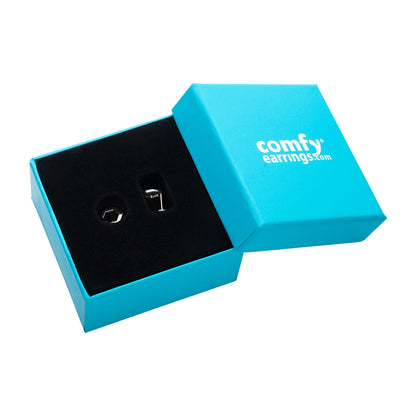 Open light blue box with Open Hexagon Titanium ComfyEarrings on a white background, featuring 'comfyearrings.com' branding.