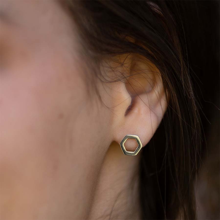 Open Hexagon Titanium ComfyEarrings worn by a person with dark hair.