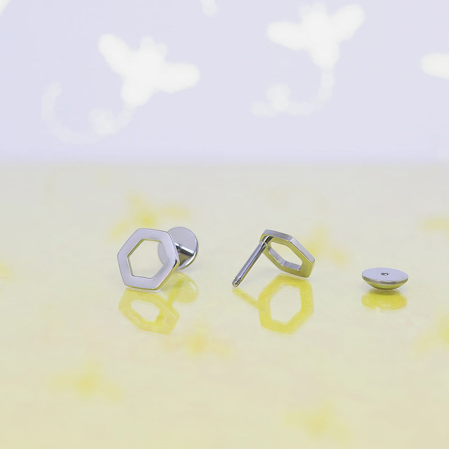 Open Hexagon Titanium ComfyEarrings -  geometric earrings on a light yellow background