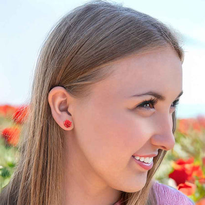 Red Rose flat back earrings in a woman's ear. 