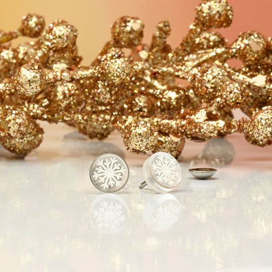 Silver snowflake earrings with a gold glittery wreath in the background