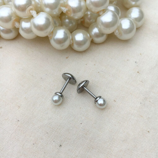 Mini Pearl ComfyEarrings in front of stranded pearls.