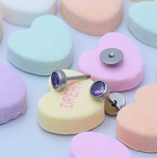 Amethyst ComfyEarrings pictured on candy Valentine's Day conversation hearts.