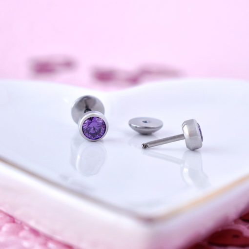Amethyst ComfyEarrings sitting on a white heart shaped dish.