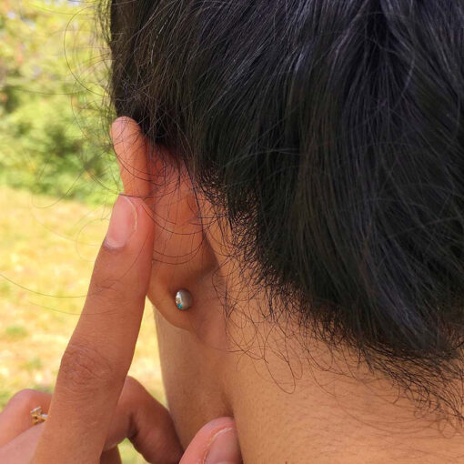 The flat back of ComfyEarrings nap earrings shown in the ear of a model.