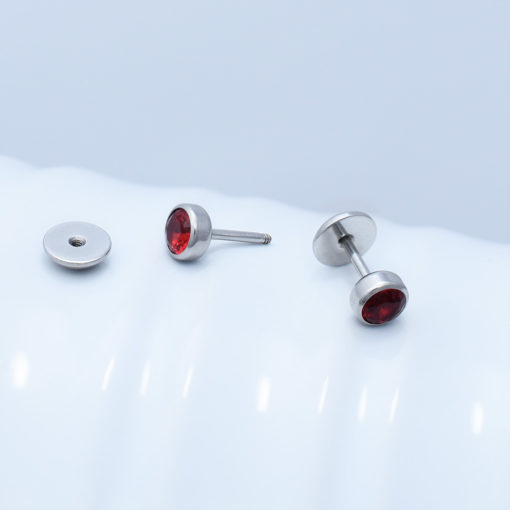 Ruby Red ComfyEarrings sitting on a white wavy vase.