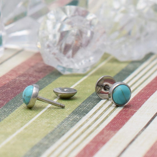 Turquoise ComfyEarrings on striped background.