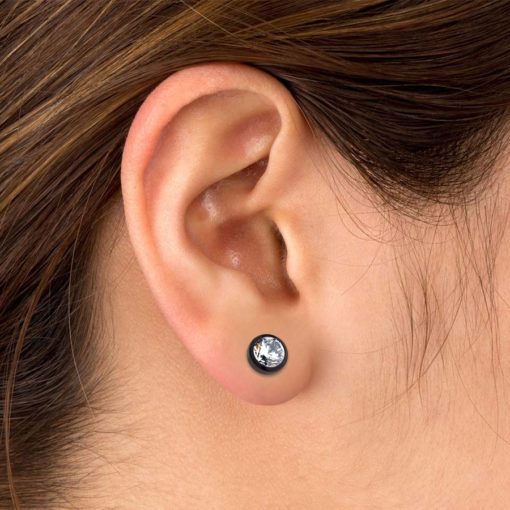 Modern Comfearrings with clear CZs and black plated bezels pictured in the ear.