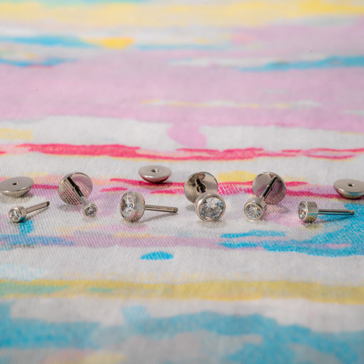 Crystal Clear ComfyEarrings sitting on blue, yellow, and pink fabric.