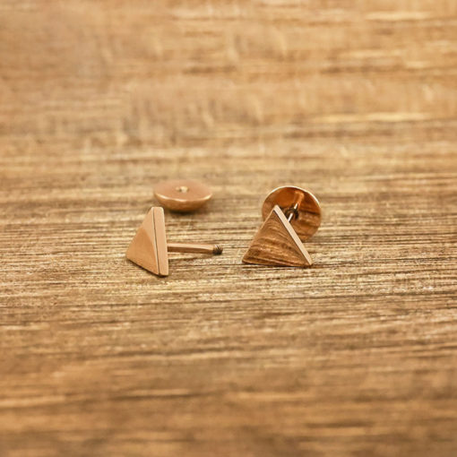 Rose Gold Triangle ComfyEarrings on grainy wood.