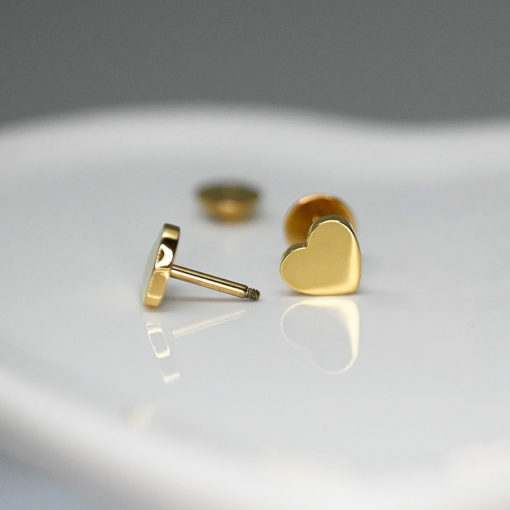 Gold Heart ComfyEarrings on white heart shape dish