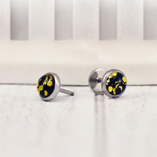 Black and Gold Funfetti ComfyEarrings on a white picket fence background
