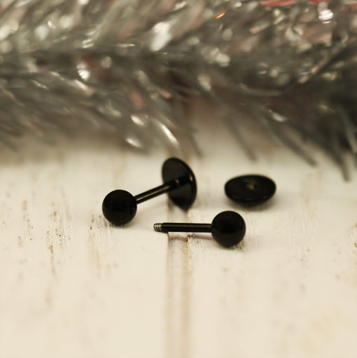 Modern Black Ball ComfyEarrings in front of silver tinsel.