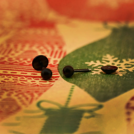 Modern Black Ball ComfyEarrings on classic wrapping paper with red and green printed ornaments