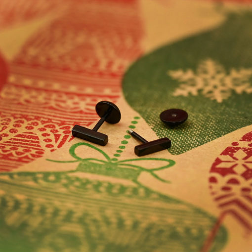Modern Black Bar ComfyEarrings on classic wrapping paper with red and green printed ornaments
