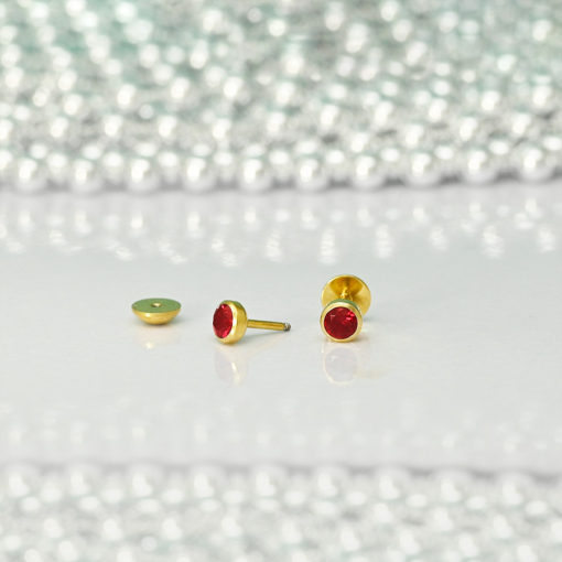 Ruby Red Gold ComfyEarrings on white dish and silver beads in background.