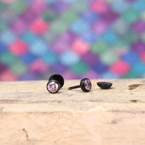Modern Rose Pink ComfyEarrings in front of a colorful background.