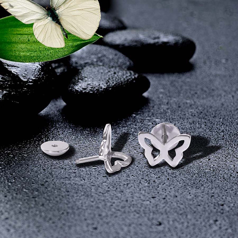 Stainless Butterfly ComfyEarrings sitting on wet dark rocks and a leaf and butterfly in the background