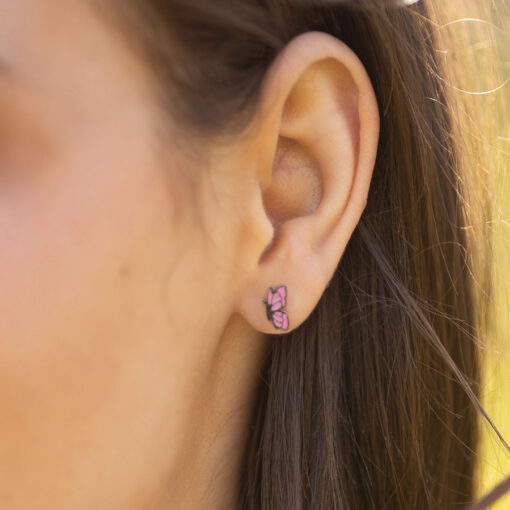 Enamel Butterfly in a models' ear. Up close image.