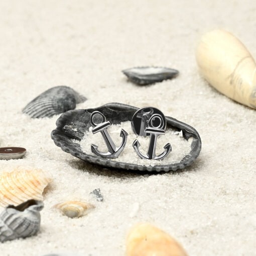 Anchor ComfyEarrings in a seashell sitting on white sand.