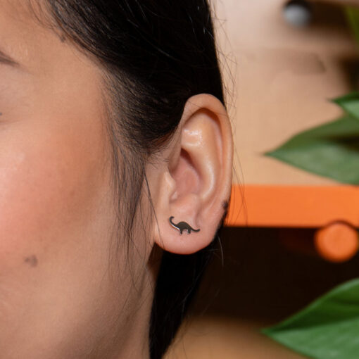 Dinosaur ComfyEarrings close up in model's ear.