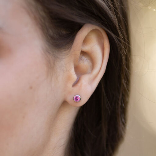 Hot Pink ComfyEarrings pictured up close in a model's ear.