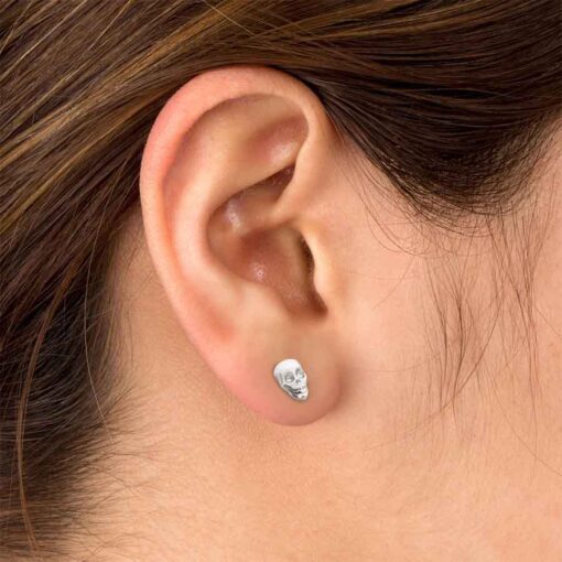 Stainless Skull ComfyEarrings pictured in a woman's ear.